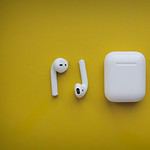 white apple airpods on yellow surface