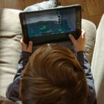 a boy is playing a video game on a tablet