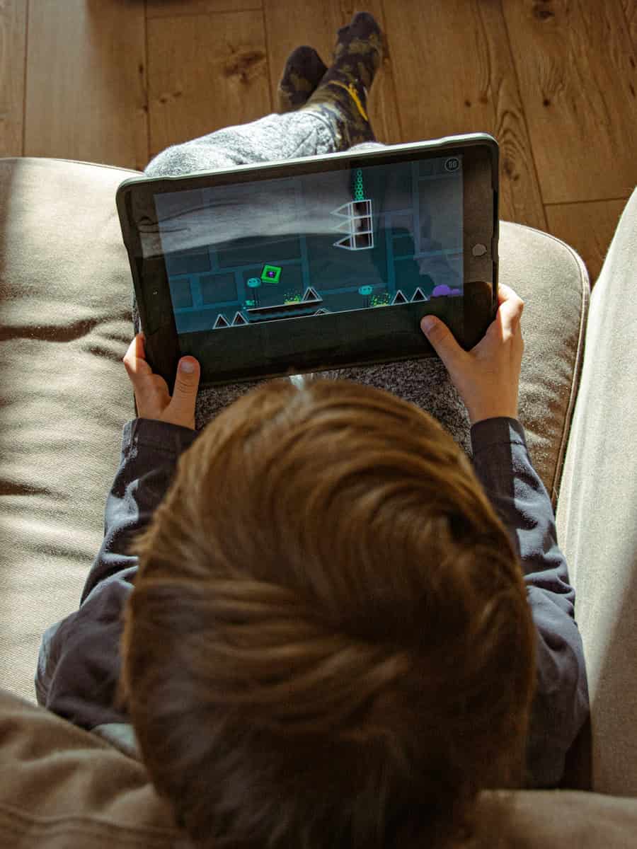 a boy is playing a video game on a tablet