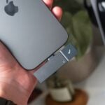 Hand holding phone with usb drive attached