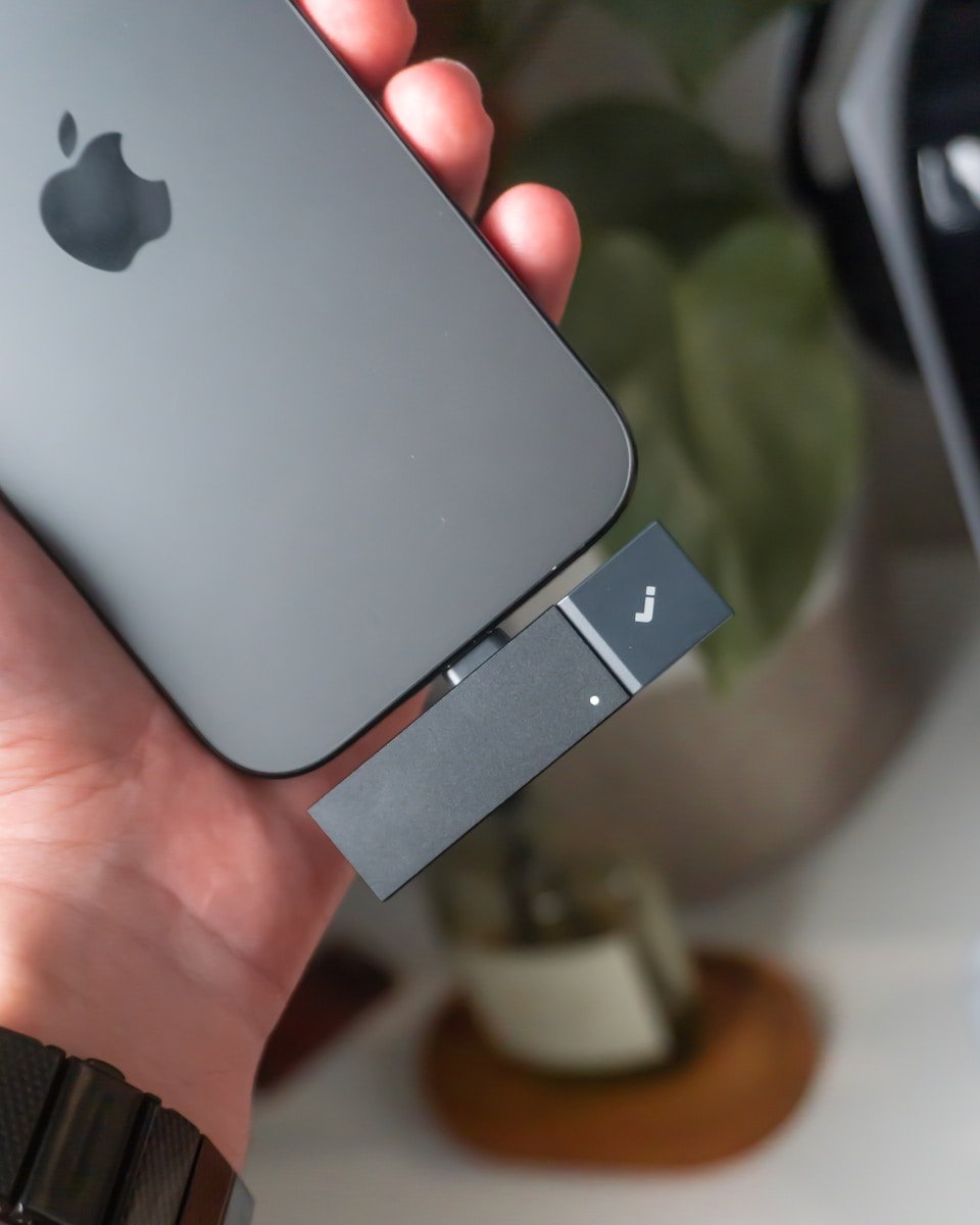 Hand holding phone with usb drive attached