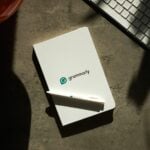 Grammarly notebook, pen, and keyboard on a desk.