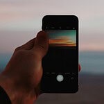 person holding smartphone taking picture