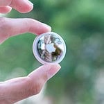 person holding silver round ornament