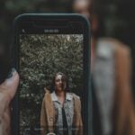 person taking photo of a woman using iPhone