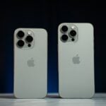 Two white iphones sitting next to each other on a table