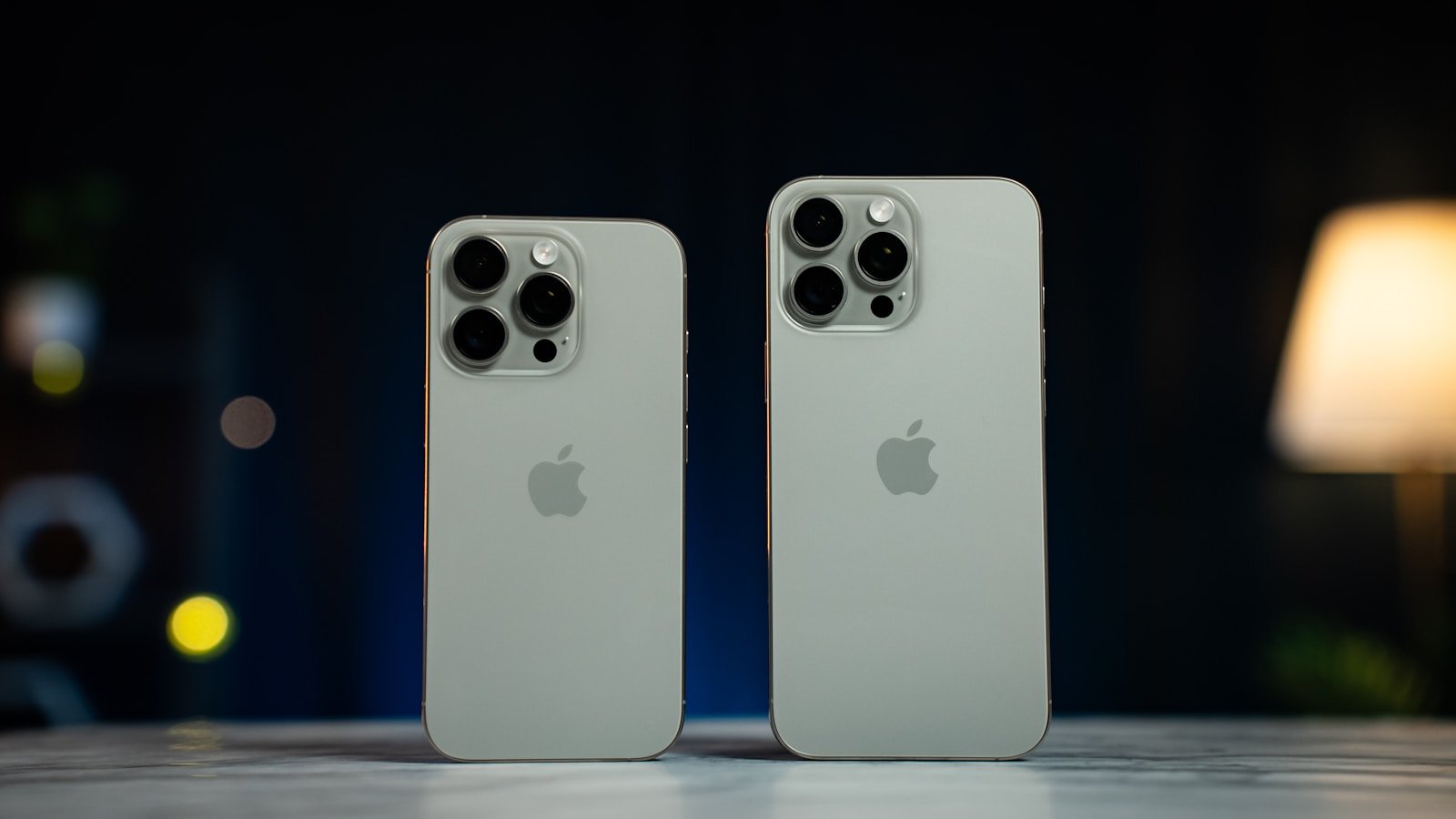 Two white iphones sitting next to each other on a table