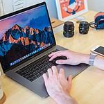 MacBook Pro turned on beside white ceramic mug