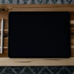 black ipad on brown wooden table