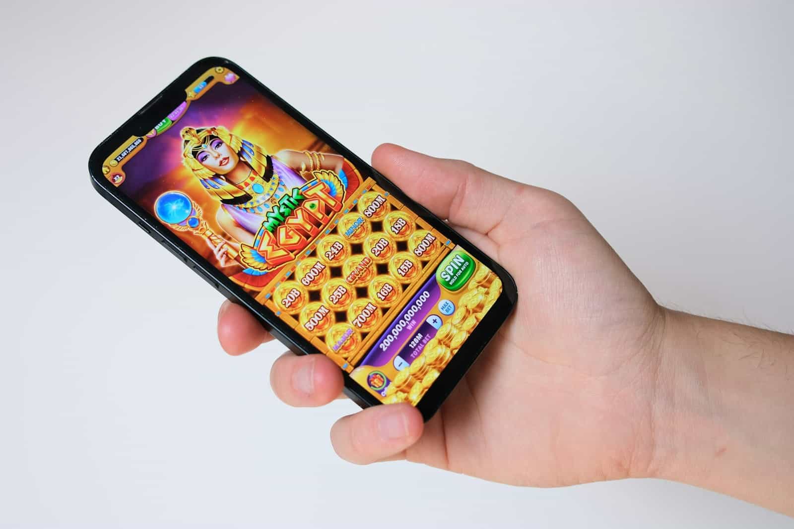 A hand holds a phone with an egyptian-themed game.