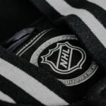 a black and white striped shirt with a badge on it
