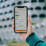 Hand holding a smartphone displaying a payment app.