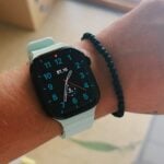 A person shows off their smartwatch and bracelet.