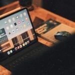 a laptop computer sitting on top of a wooden desk