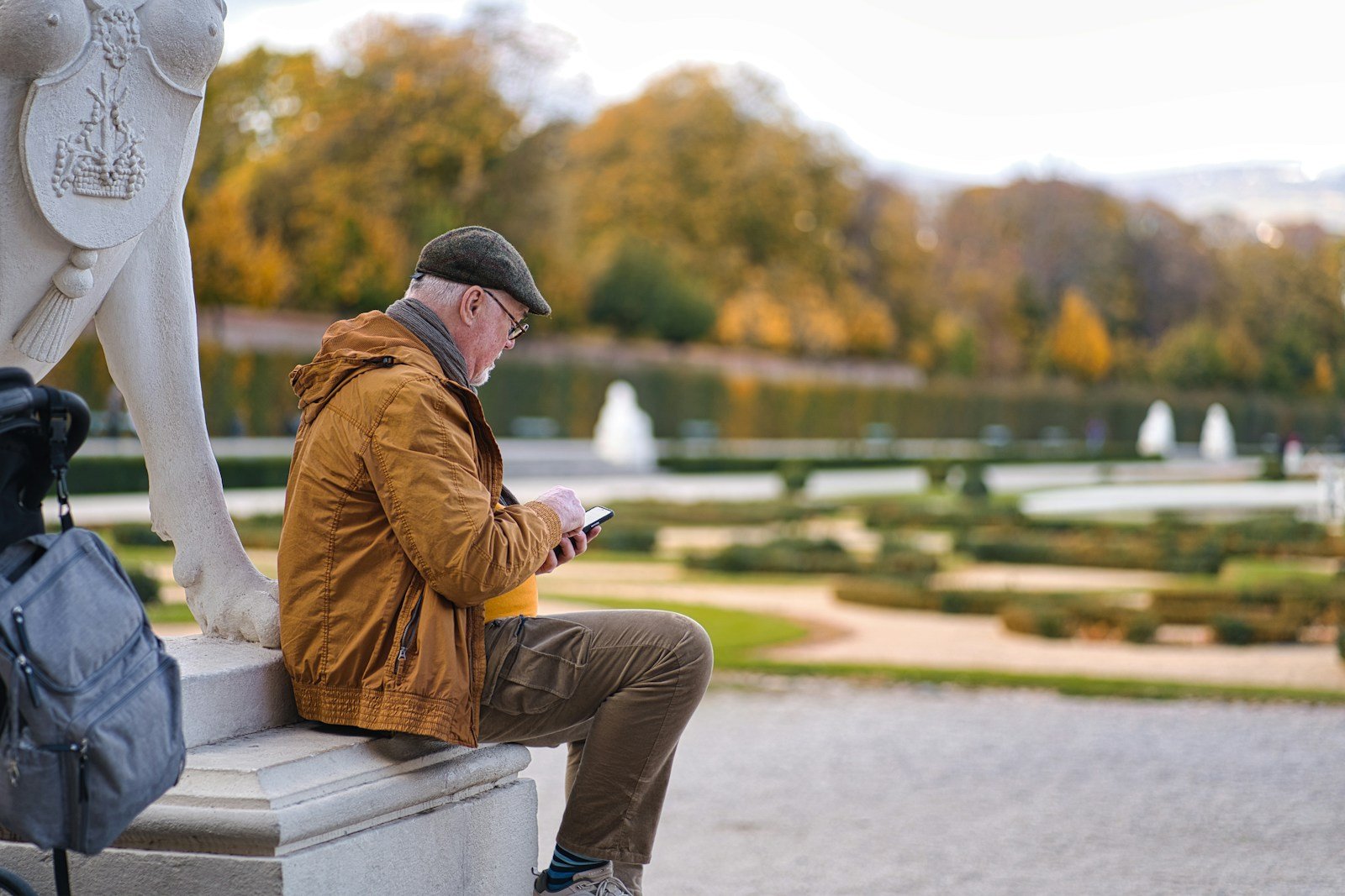a man sitting on a bench looking at his phone