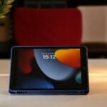 a tablet sitting on a table next to a candle