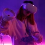a woman holding a video game controller in her hand