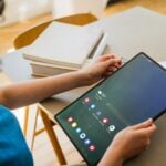 A woman sitting at a table with a tablet