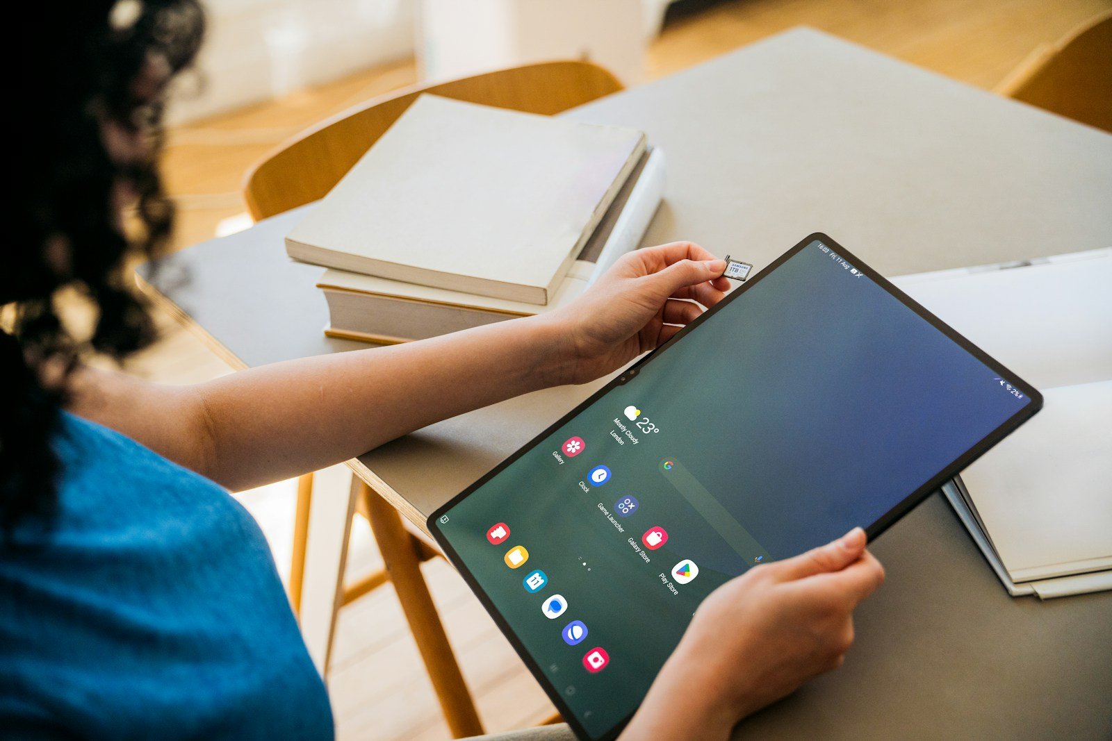 A woman sitting at a table with a tablet