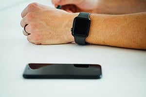 black smartphone near person's hand wearing black smartwatch