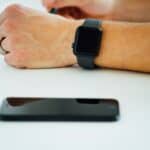 black smartphone near person's hand wearing black smartwatch