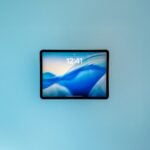 A tablet displaying a blue abstract wallpaper.