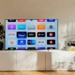 a flat screen tv sitting on top of a white cabinet