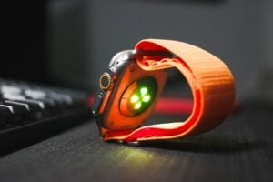 a close up of a watch on a desk near a keyboard