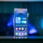 A cell phone sitting on top of a table next to a lamp