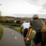 man in brown t-shirt riding on bicycle on road during daytime