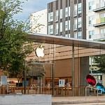 an apple store with a sculpture in front of it