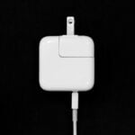 a close up of an apple charger with a black background