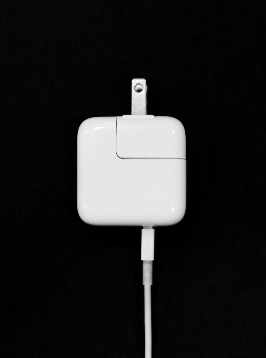 a close up of an apple charger with a black background