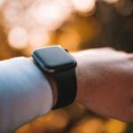 person wearing silver aluminum case apple watch with white sport band
