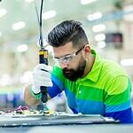 a man in a factory working on a piece of equipment